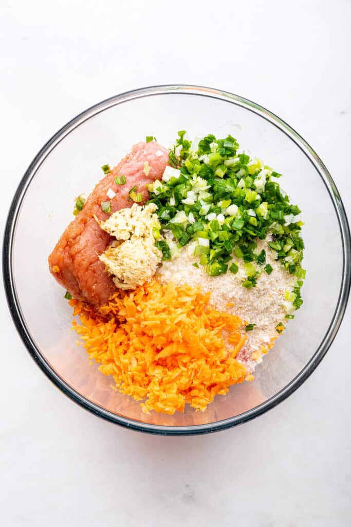 Overhead view of ingredients for Asian turkey meatballs in glass bowl