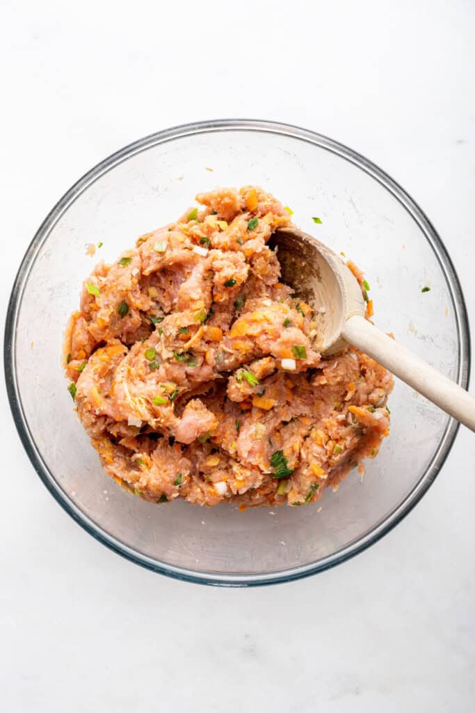 Overhead view of meat mixture for Asian turkey meatballs in mixing bowl