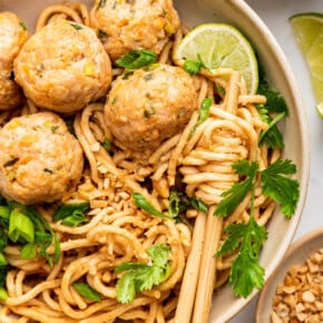 Overhead view of Asian turkey meatballs in bowl with noodles and chopsticks