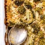 Digging into the quinoa casserole in the baking dish with a metal spoon.