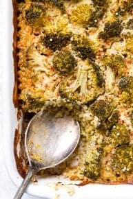 Digging into the quinoa casserole in the baking dish with a metal spoon.