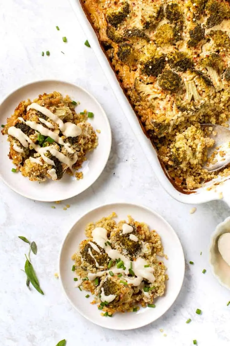 Two pieces of casserole with tahini on serving plates and the baking dish on the side. 