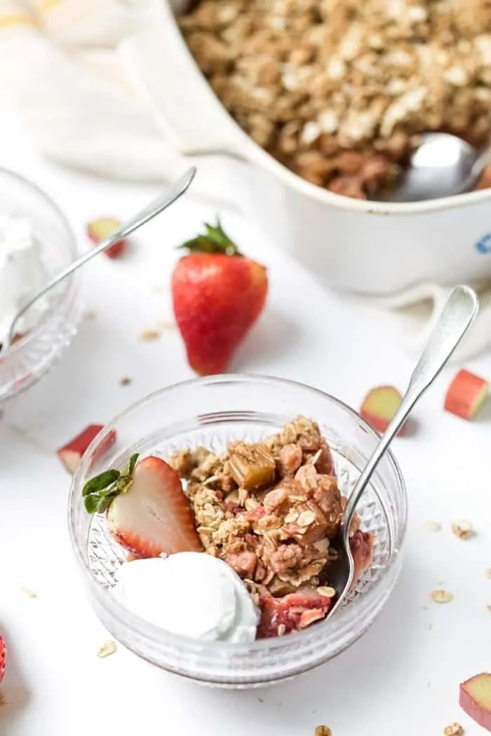 Glass bowl with serving of strawberry rhubarb crisp