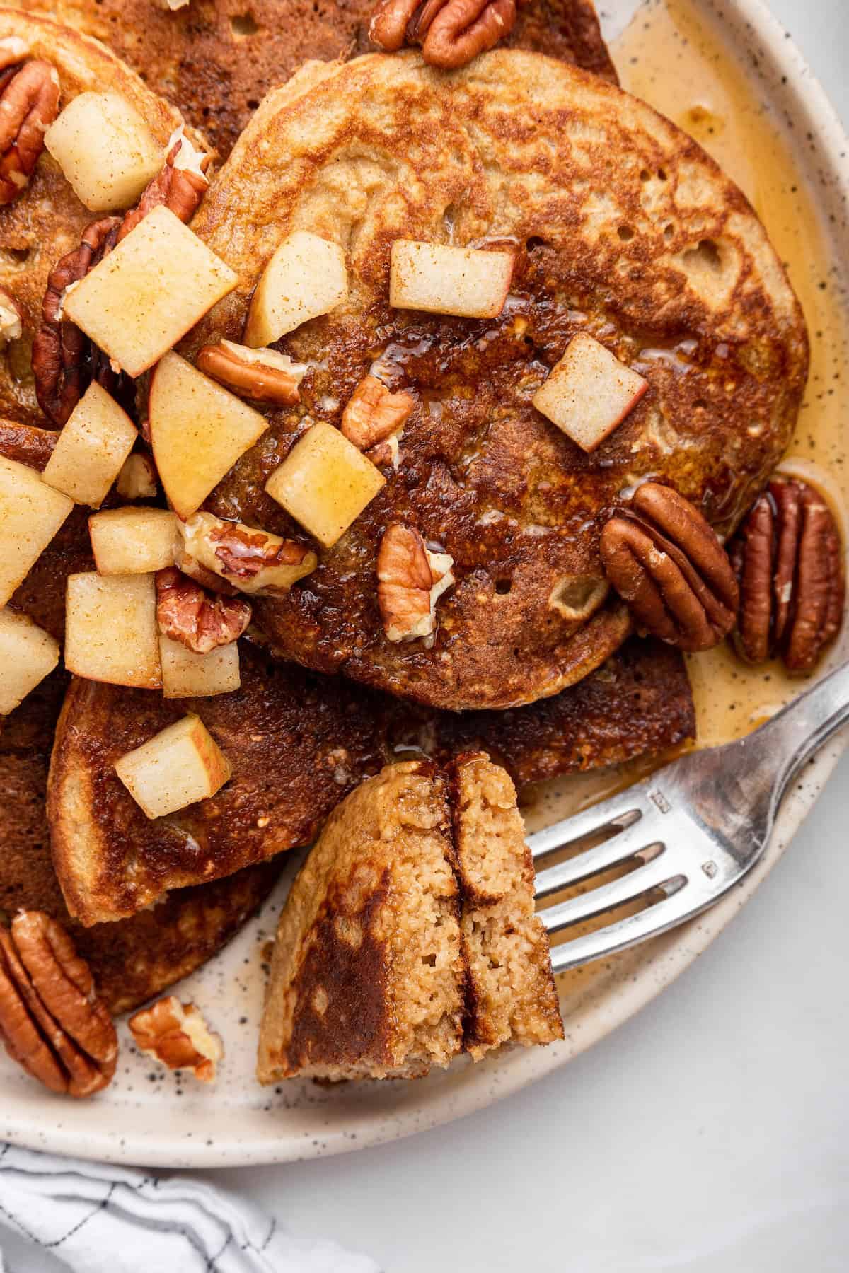 Fork digging into pieces of oatmeal pancakes