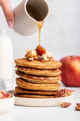 Pouring syrup onto oatmeal pancake stack