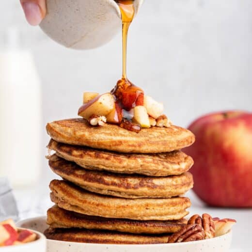 Pouring syrup onto oatmeal pancake stack