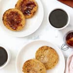 Toasted Gluten-Free English Muffins; one topped with butter and one topped with jam