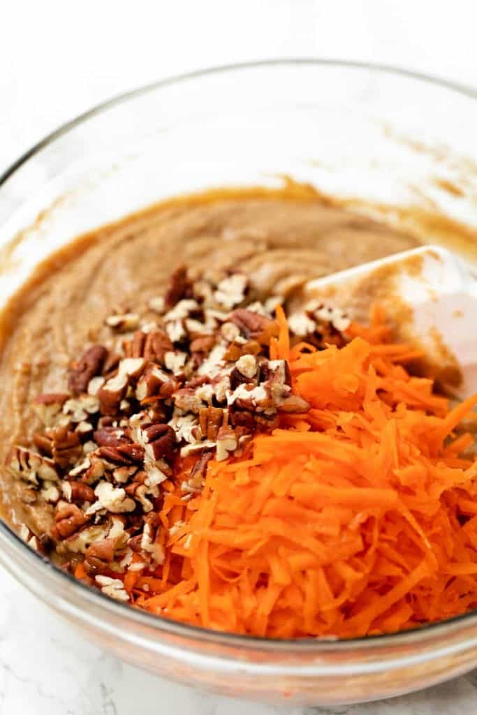 Folding carrots and nuts into batter for carrot cake