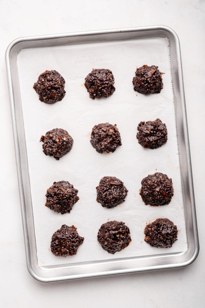 Overhead view of no-bake chocolate cookies on parchment-lined baking sheet