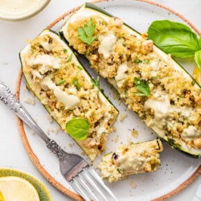 Overhead view of two stuffed zucchini boats on plate