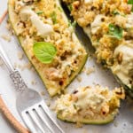 Quinoa stuffed zucchini boats on plate with bite from end