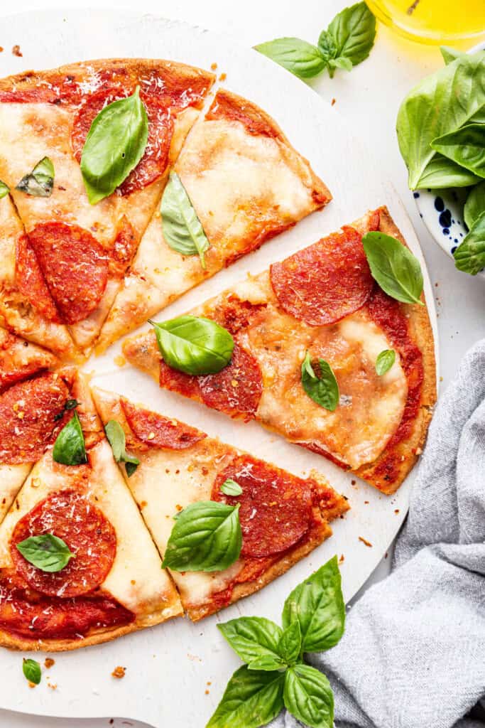 Pepperoni almond flour pizza sliced on board