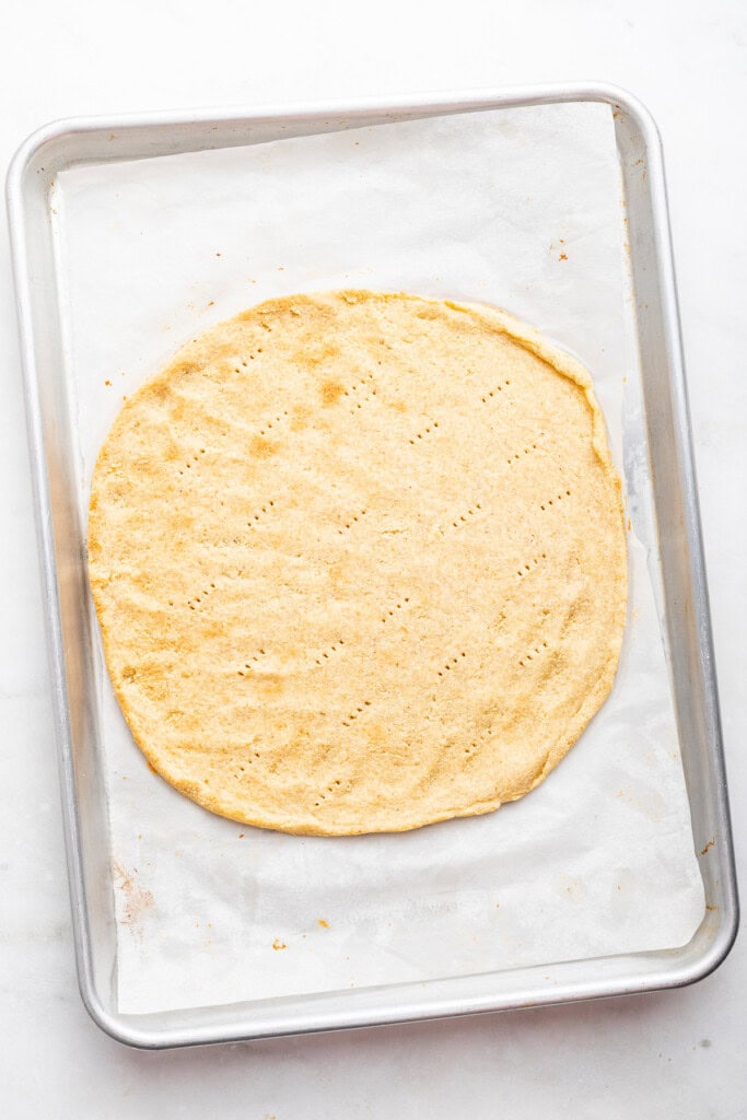 Overhead view of almond flour pizza crust on sheet pan