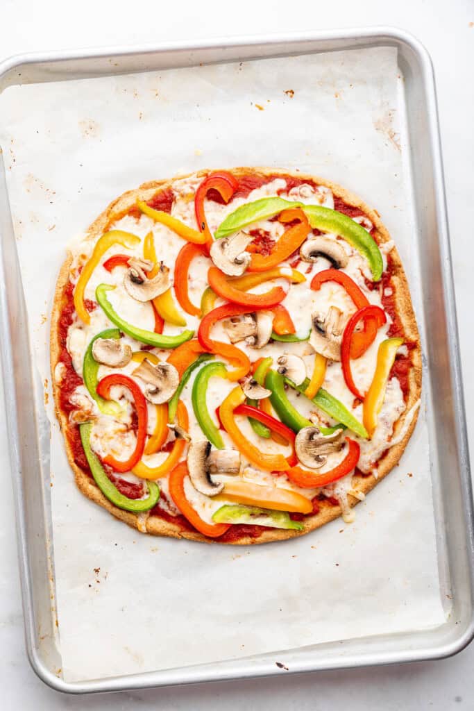 Overhead view of almond flour pizza on sheet pan