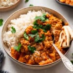 bowl of lentil curry with rice and naan