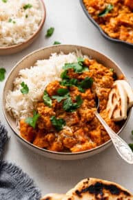 bowl of lentil curry with rice and naan