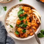 bowl of sweet potato and red lentil curry with rice and naan