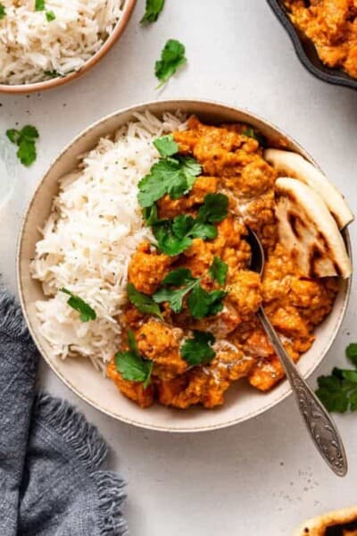 bowl of sweet potato lentil curry with rice and naan