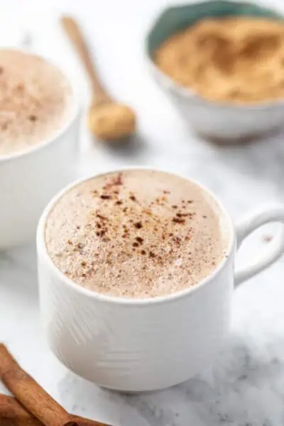 Two maca coffees in white mugs side by side.