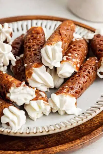 A plate full of finished filled brandy snaps