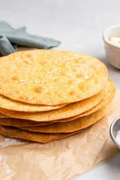 A stack of tostada shells on a sheet of parchment paper.