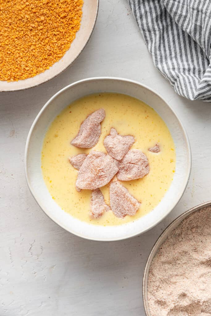 Chicken being soaked in the milk mixture.