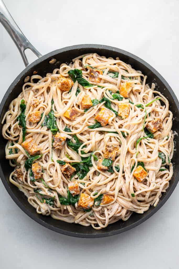 Overhead view of walnut pasta in skillet with butternut squash