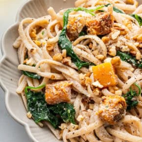 Walnut pasta with butternut squash and spinach in bowl