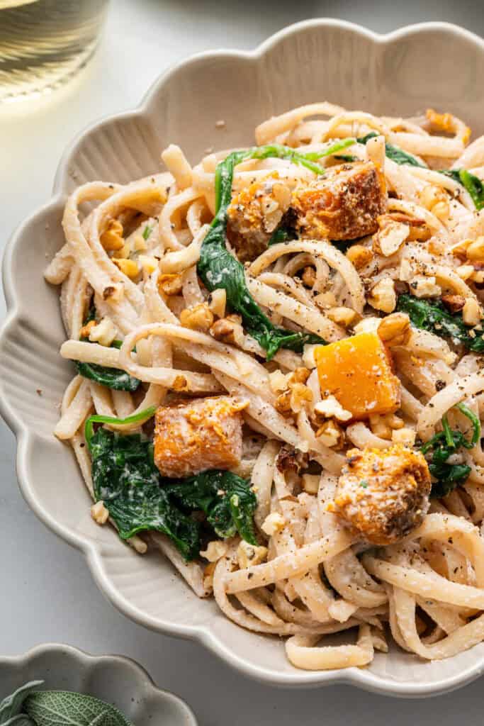 Walnut pasta with butternut squash and spinach in bowl