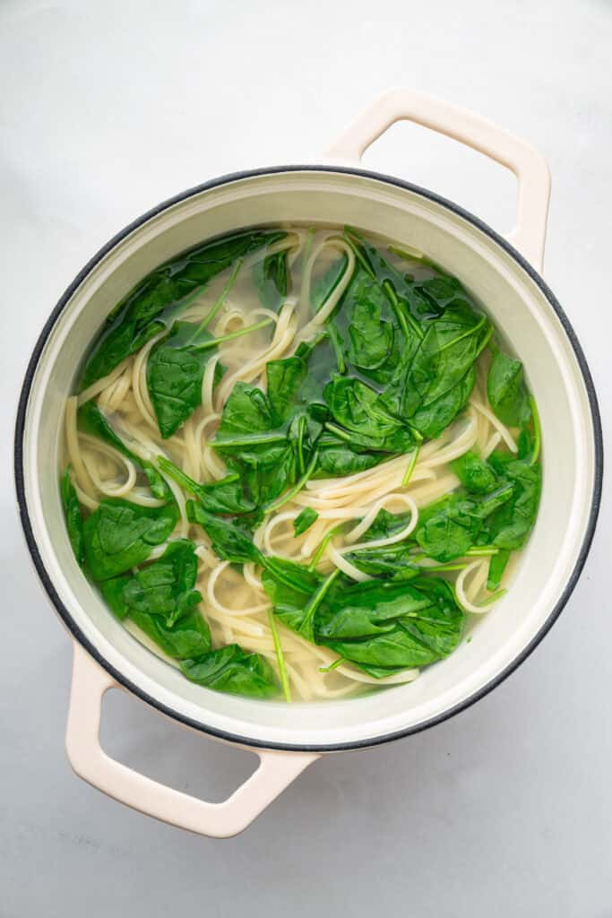 Pasta and spinach in pot of water