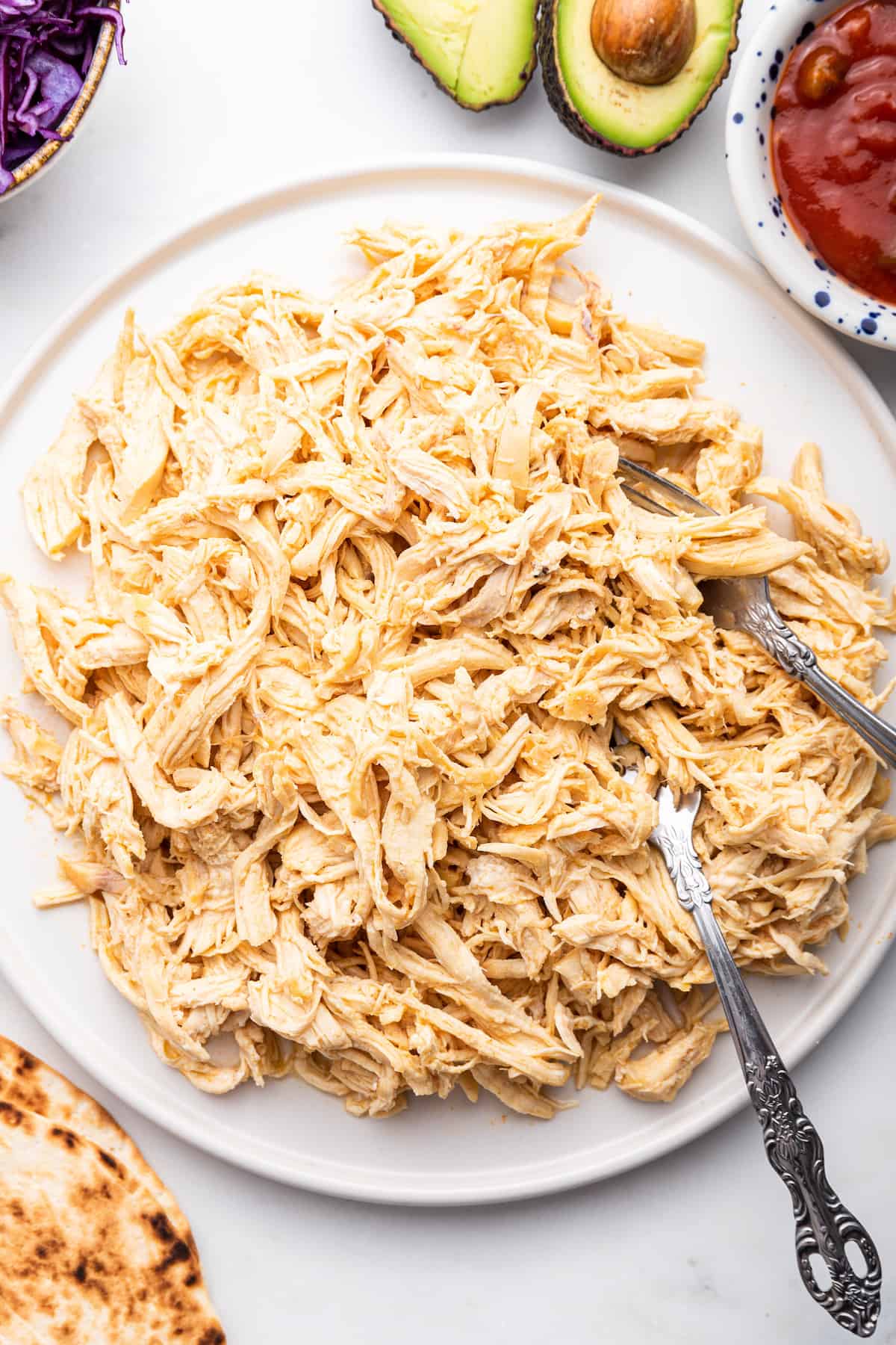 Overhead view of Instant Pot shredded chicken on plate with forks