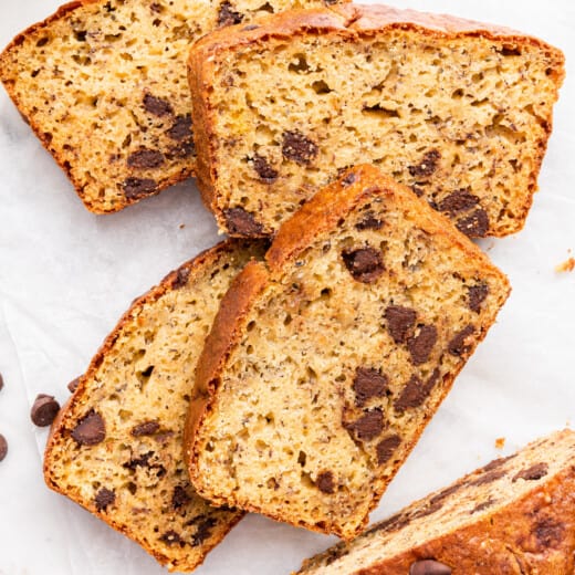 Overhead view of protein 4 banana bread slices laying on countertop next to remaining loaf