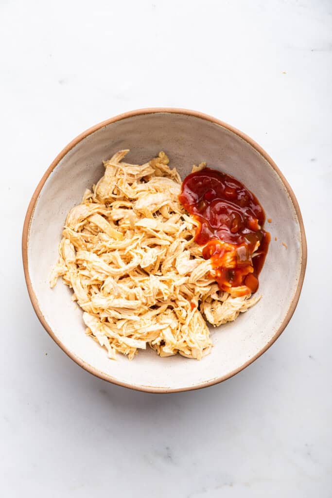 Overhead view of salsa and shredded chicken in bowl