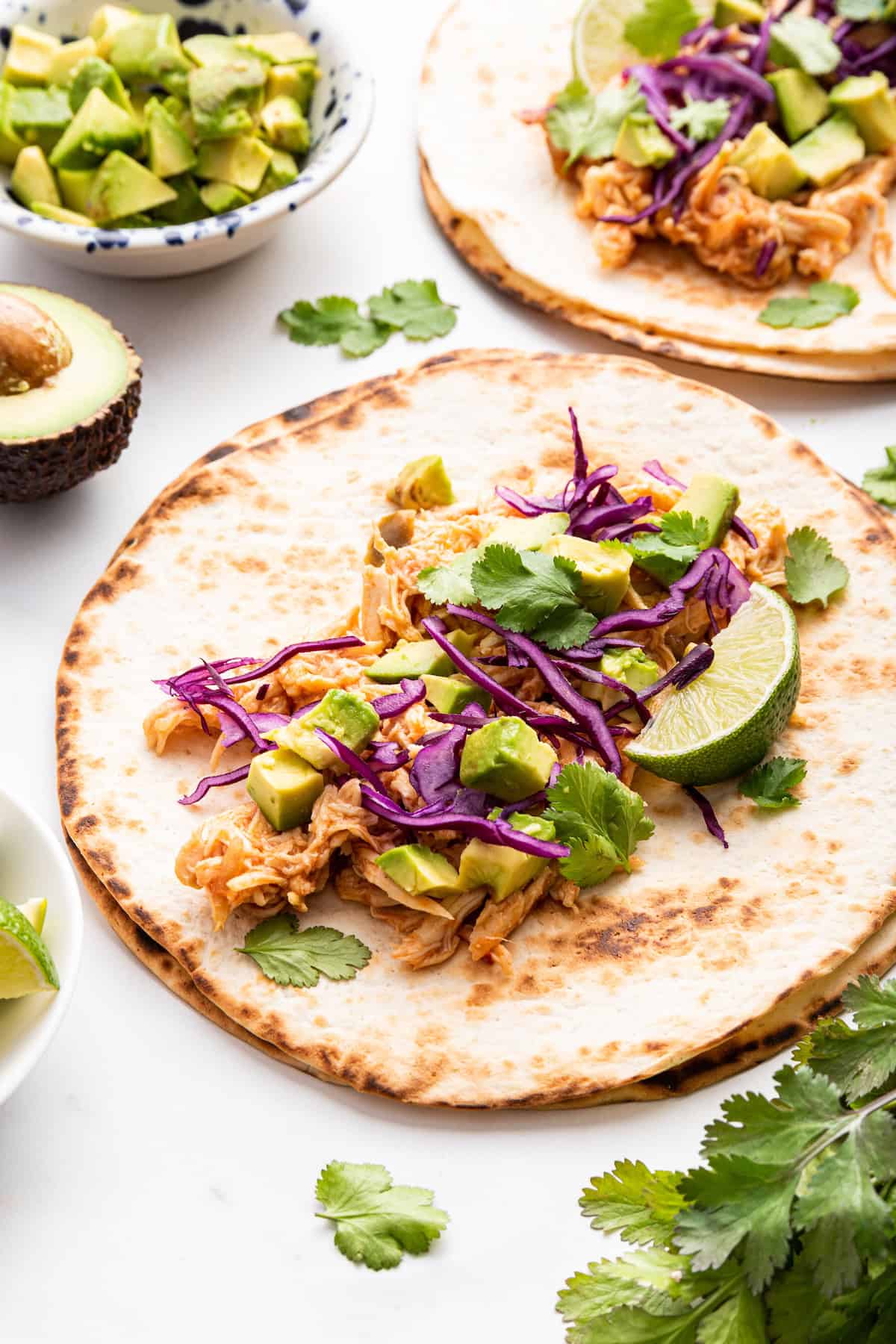 Instant Pot shredded chicken and toppings on toasted tortilla for taco