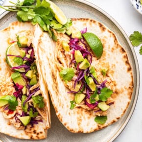 Overhead view of shredded chicken tacos on plate