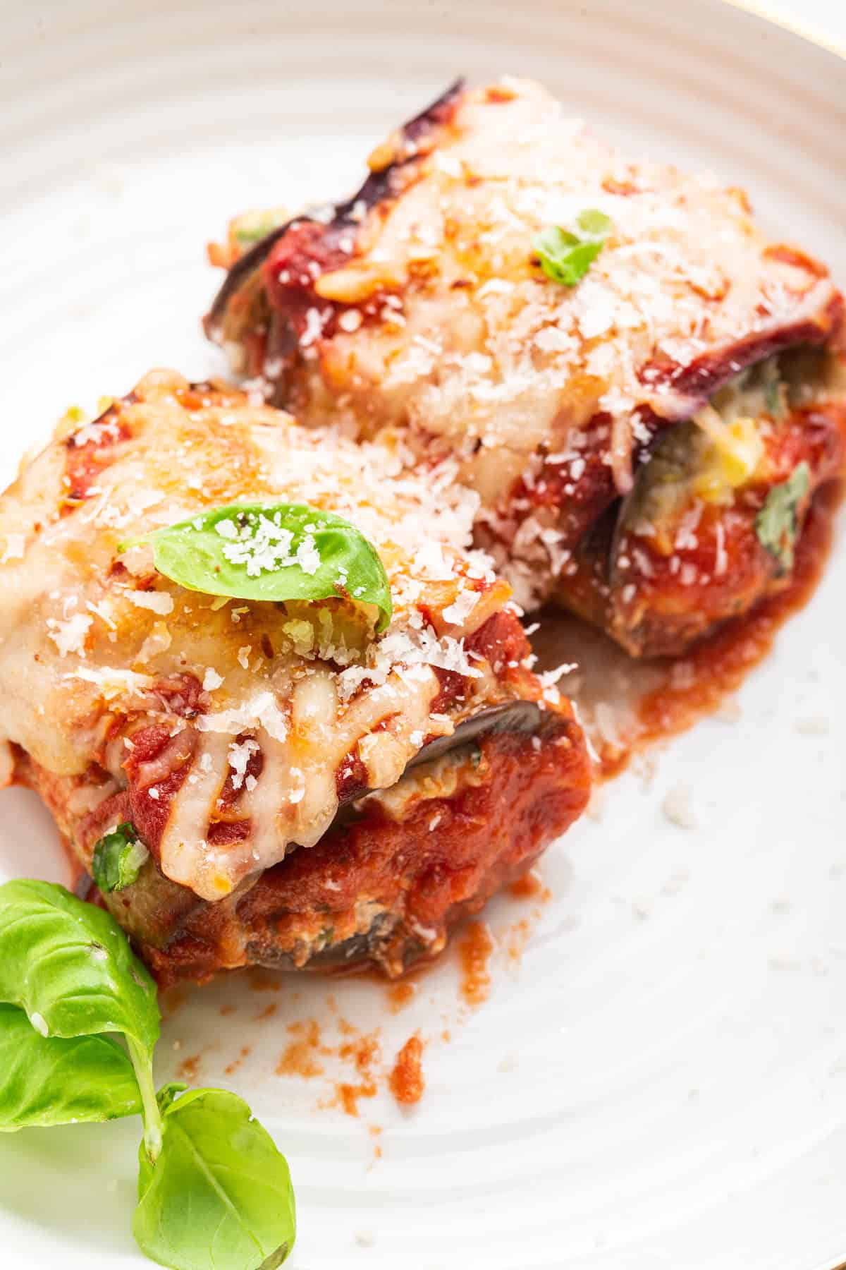 Closeup of two eggplant rollatini on plate