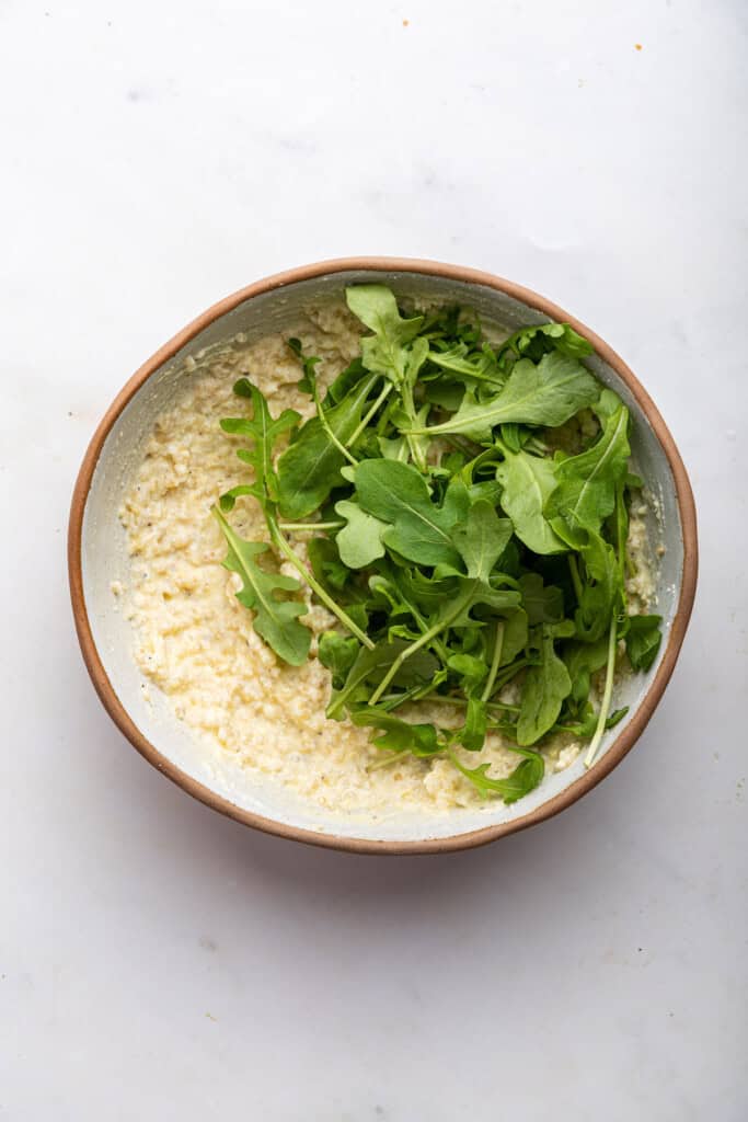 Arugula added to cheese and quinoa mixture