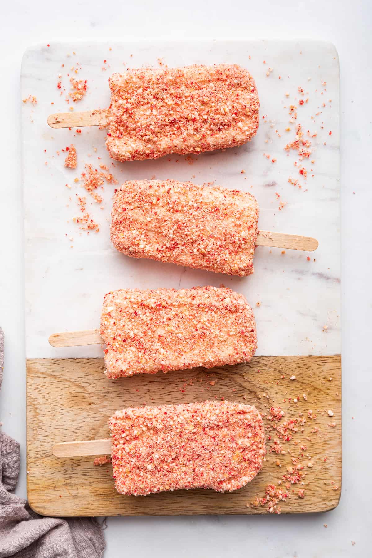 Overhead view of strawberry shortcake ice cream bars on wood and marble board