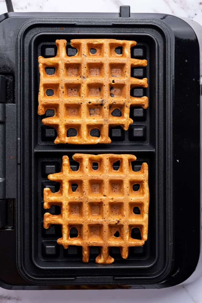 Overhead view of blueberry waffles in waffle maker