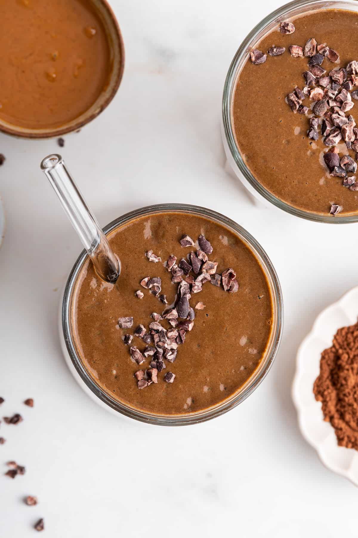 Overhead view of chocolate peanut butter smoothies with cacao nibs for garnish