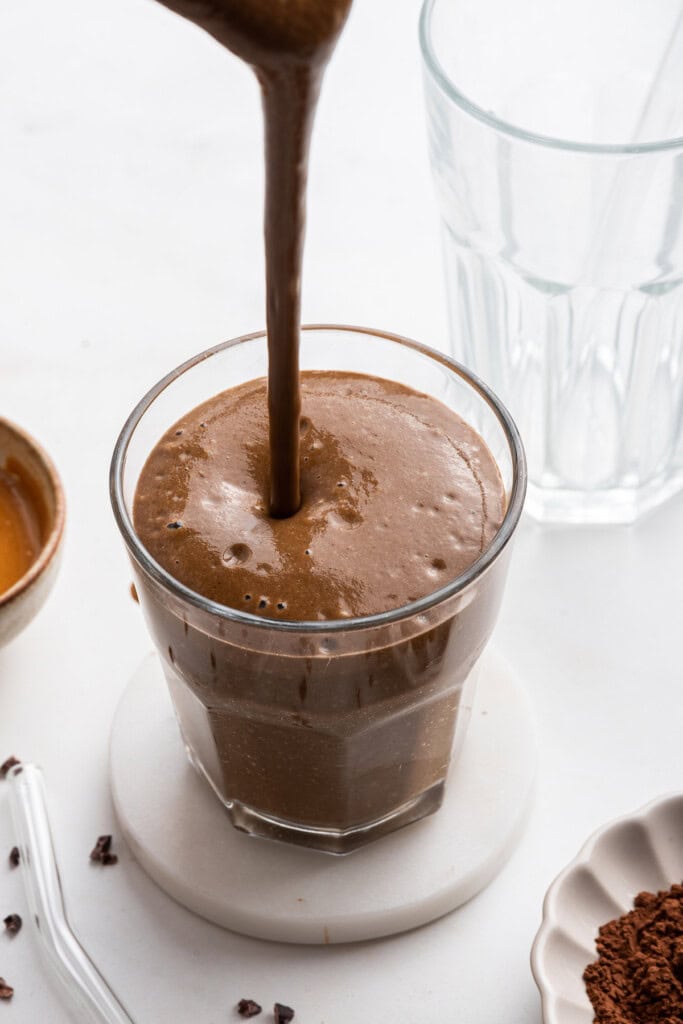 Pouring chocolate peanut butter smoothie into glass