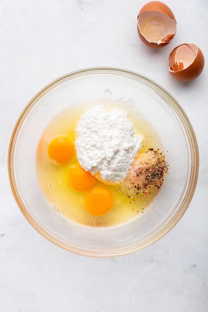 Eggs, cottage cheese, salt, and pepper in bowl