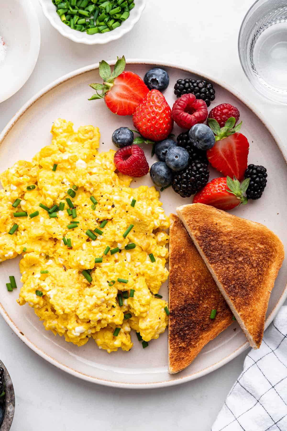 Plate with cottage cheese eggs, fresh berries, and toast