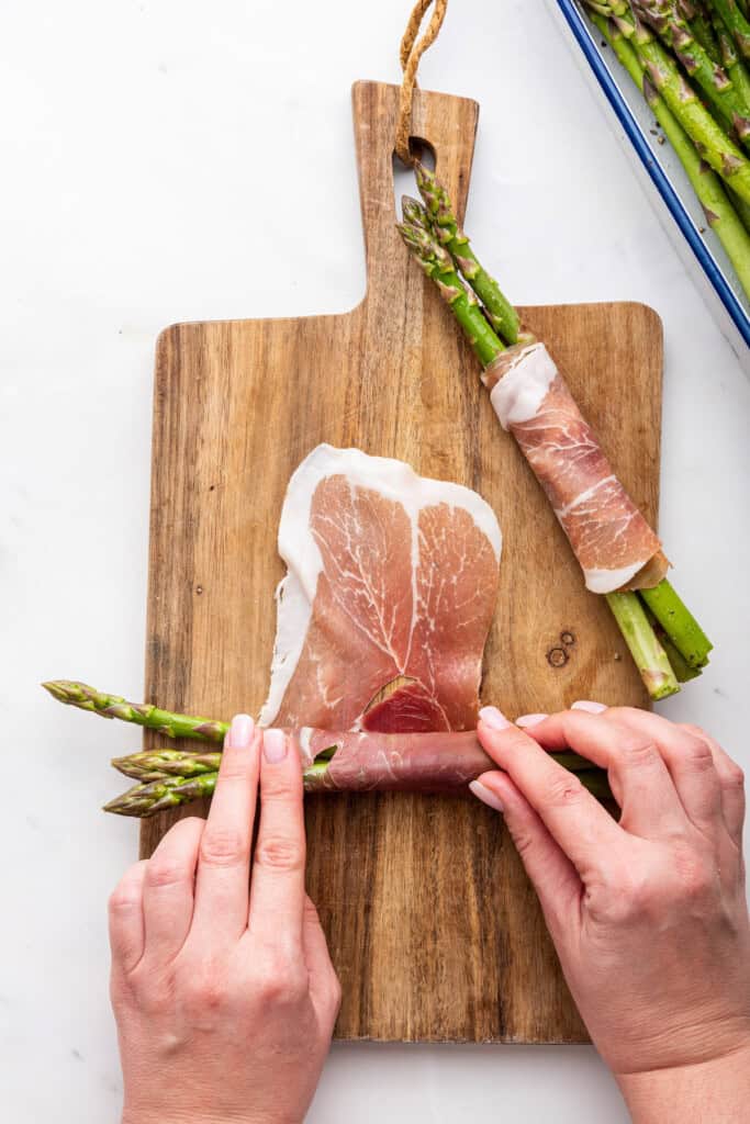 Rolling asparagus spears in prosciutto