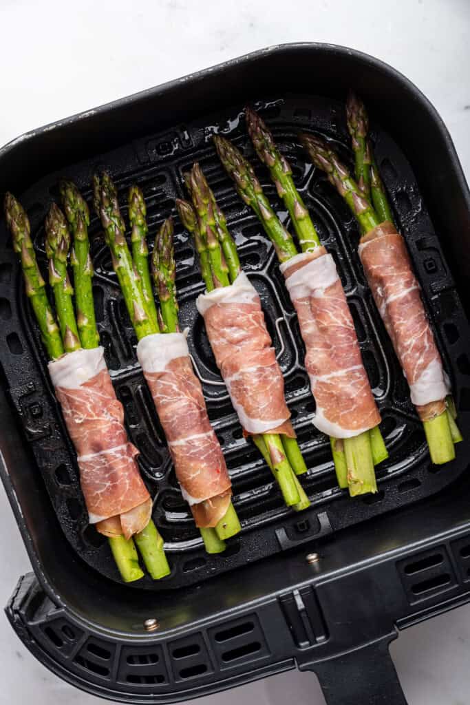 Uncooked prosciutto wrapped asparagus in air fryer