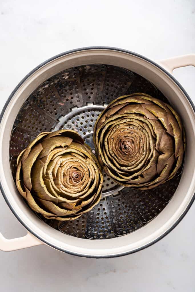 Two artichokes in steamer basket