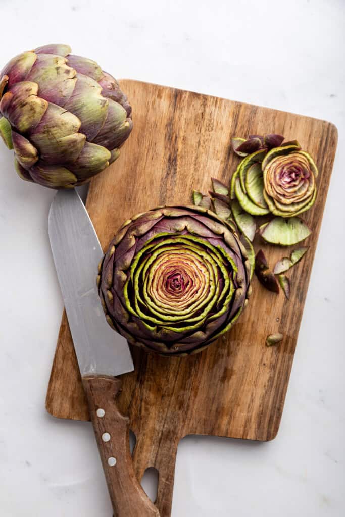 Overhead view of trimmed artichoke on cutting board