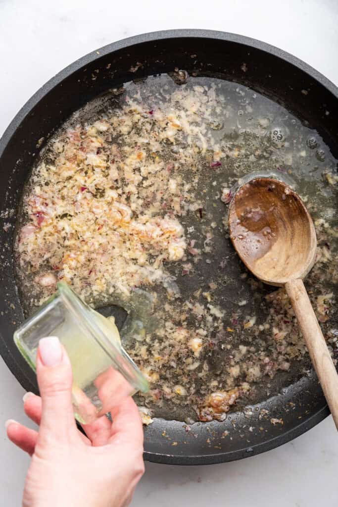 Pouring lemon juice into skillet