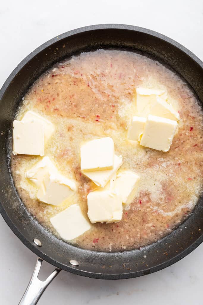 Butter added to skillet with lemon juice, wine, and shallots