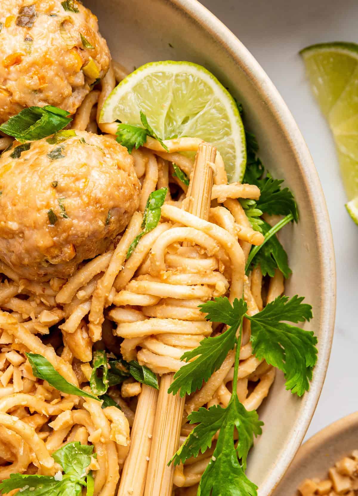 Overhead view of peanut noodles wrapped around chopstick